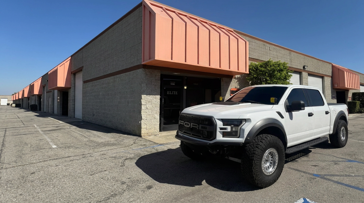 White Ford Raptor with dark tinted windows outside the 310 Tintz shop